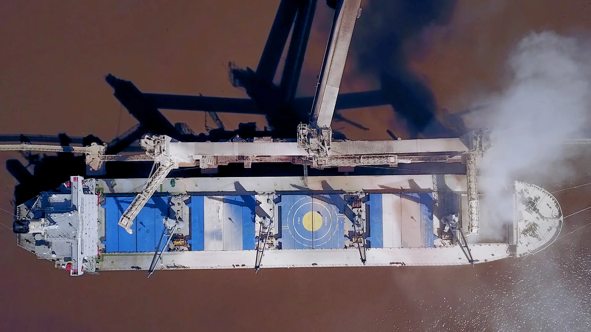 Vista aérea de un buque durante una operación de carga en una terminal portuaria de Rosario